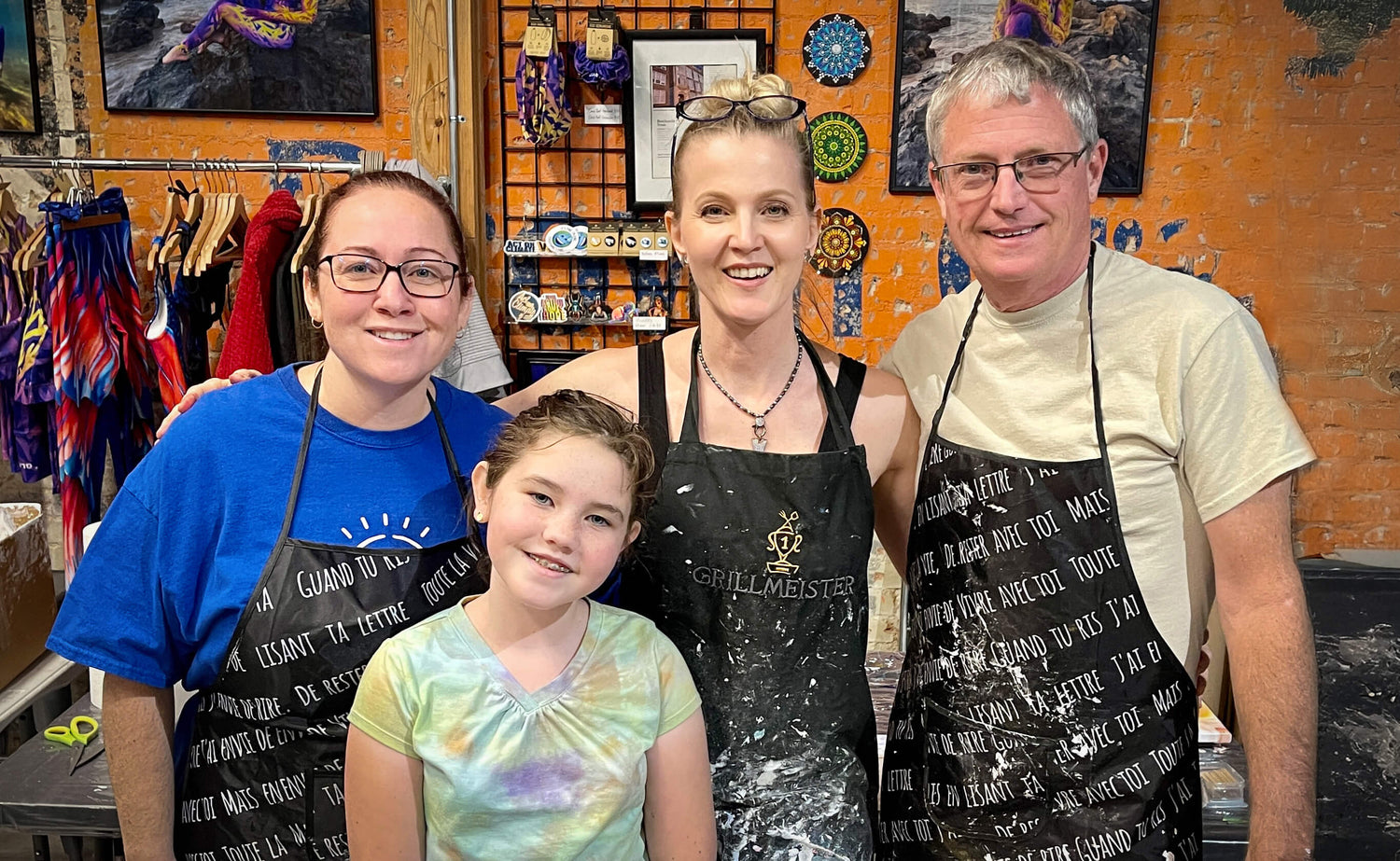 Anja Yamaji with three smiling students posing for the camera after an acrylic flow experience at her Dallas studio.